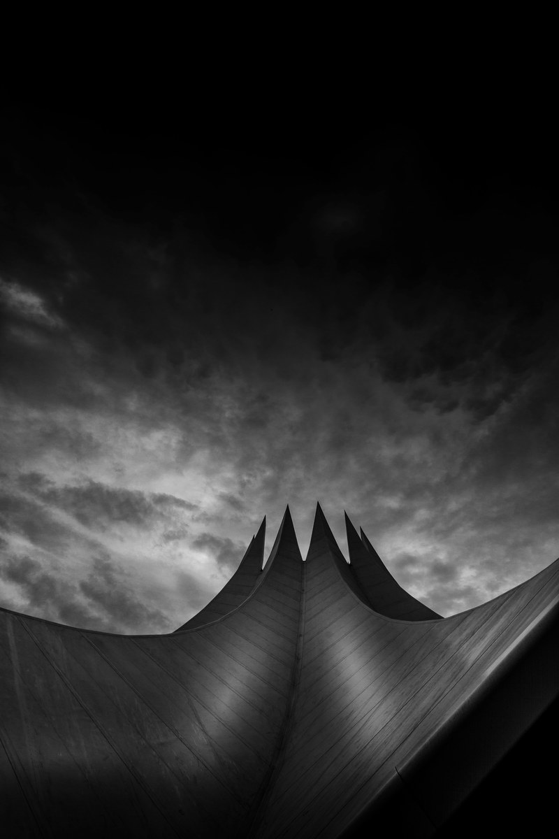 unique architecture of a modern building against a cloudy sky, tempodrom berlin monochrome 4k