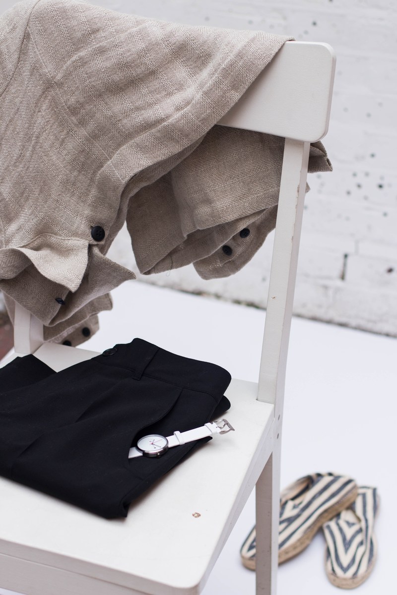 clothes and a watch on a white wooden chair, clothing draped on chair 4k