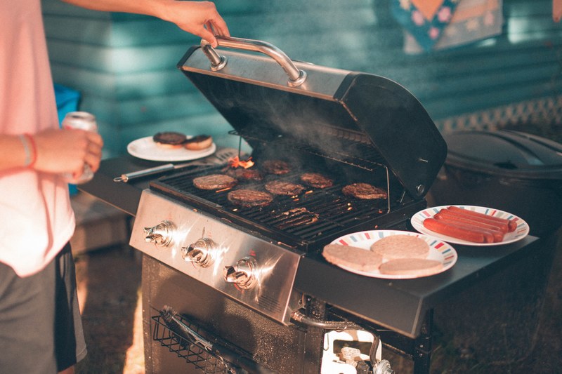 a man cooking barbecue on a grill in a summer party at wasaga beach, bbq day 4k