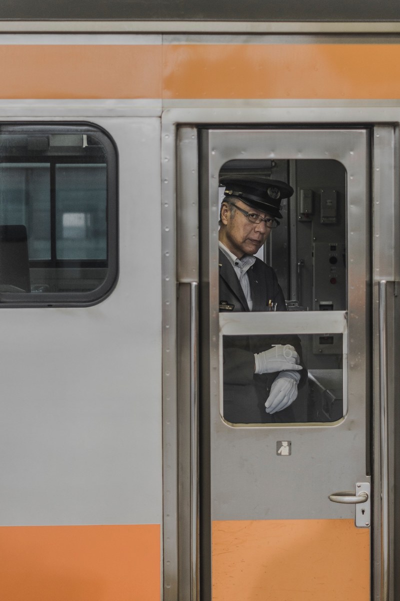 a male train conductor with white gloves in one of the subway trains in tokyo, _tokyo 4k