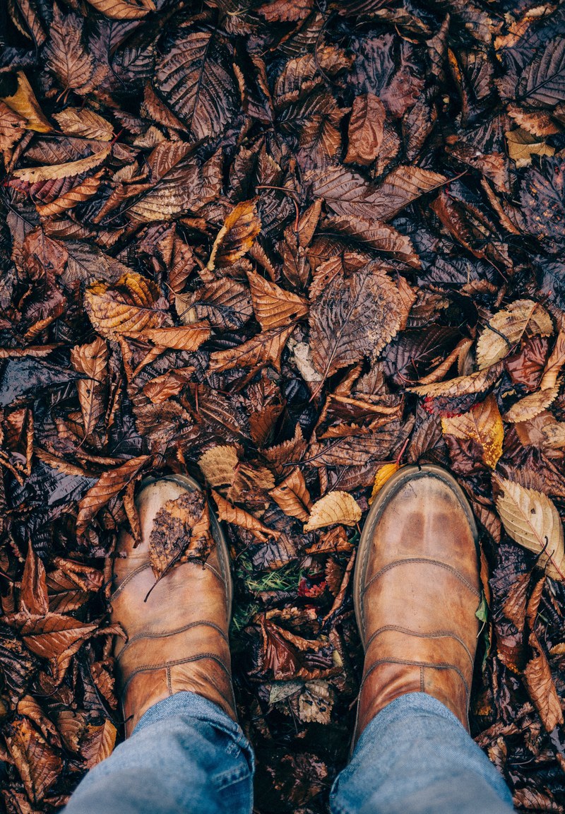 staring down at denim jeans and brown shoes on the ground of an autumn trail pathway, letchworth garden city in fall 4k