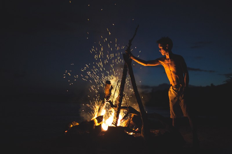 a man building a bonfire at mcgregor point at night, mcgregor point bonfire 4k