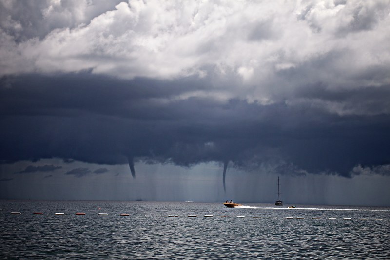 speedboat speeding across the sea with waterspout tornadoes in the distance in budva municipality, waterspout tornado budva 4k