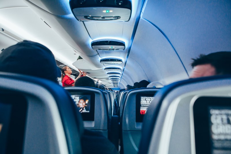 view from the back of a plane on the rows of seats stretching to its nose, on a long plane flight 4k