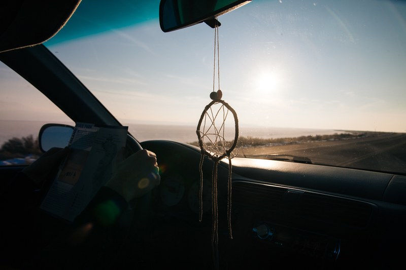 interior shot from car with dreamcatcher driving on coastal road on antelope island, driving on coastal road on antelope island 4k