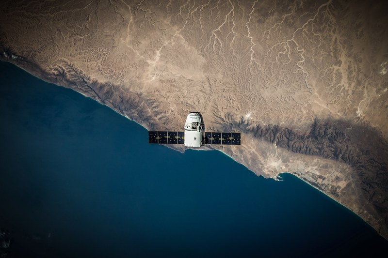 a space satellite hovering above the coastline, satellite over the coast 4k