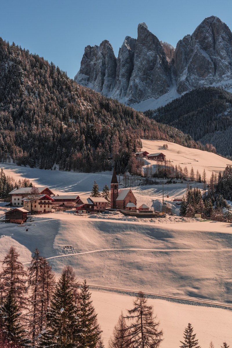 a small village with a church near tall jagged mountain peaks, val di funes 4k