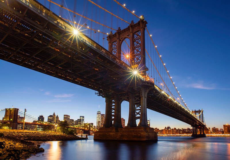 the new york city skyline and manhattan bridge at sunset, manhattan in ...