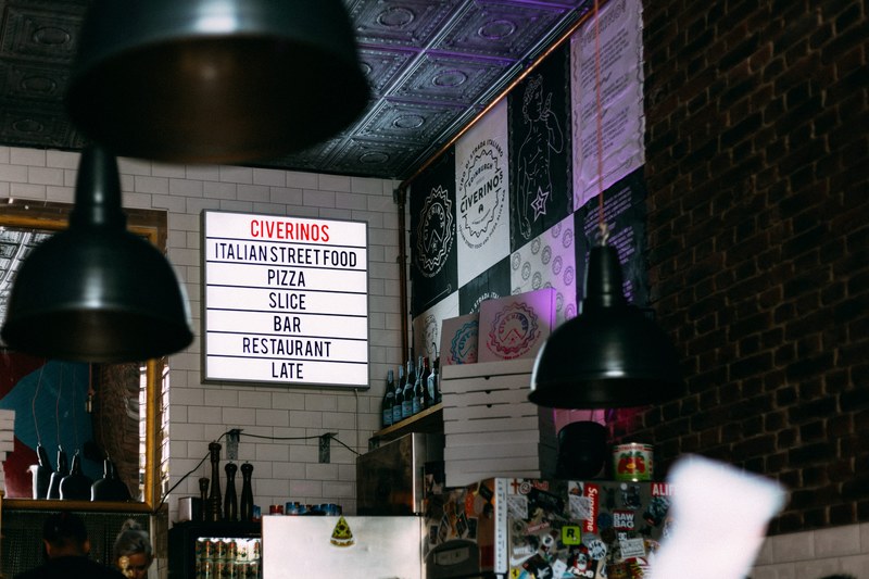 the walls of a bistro with signs posters and refrigerators, civerinos italian street food 4k