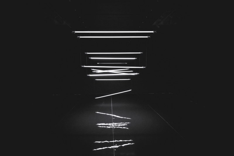 a unique shot of tube lights falling from the ceiling in a dark room, _falling tube lights 4k