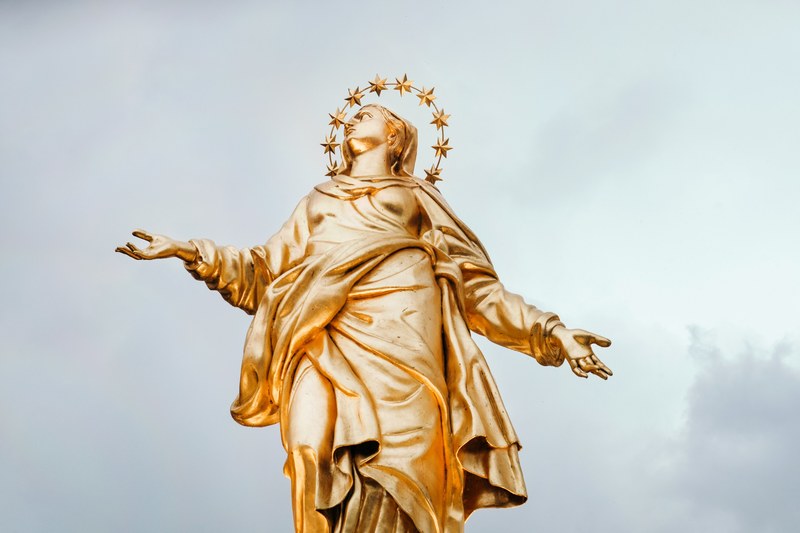 gold religious statue of figure wearing regal halo in heavenly pose milan, golden statue in milan 4k