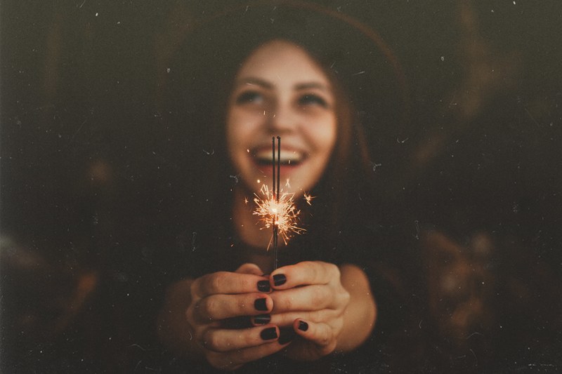 a woman in a hat with painted nails holds out sparklers in cianorte, woman holds out sparklers 4k