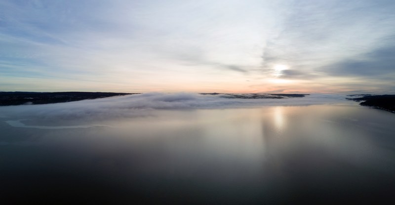 cloudy sunrise reflects off the sea water in nesoddtangen norway, fog over lake in oslo norway 4k
