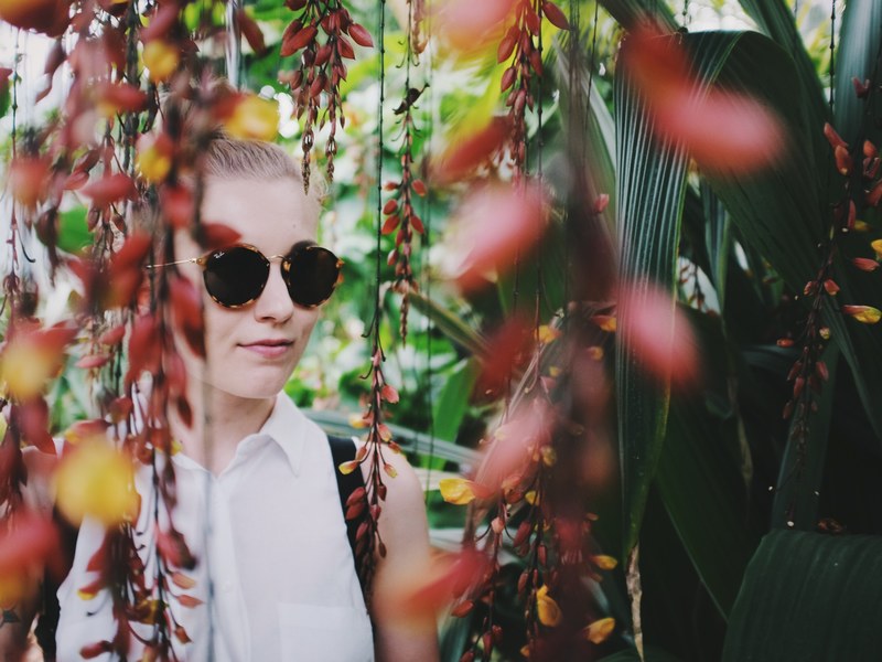 a woman in sunglasses walks through a hanging garden in tokyo, zen capital 4k