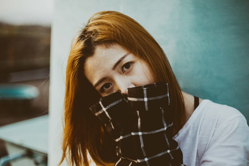 shy woman covering her face with her shirt sleeves, feeling shy 4k