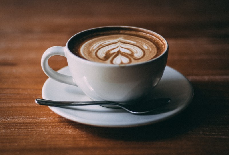 cappuccino in a white cup on a saucer with foam art and a small spoon, cappuccino on a saucer 4k
