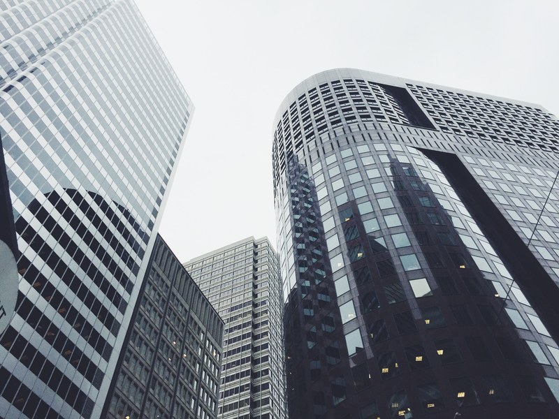 high rise facades in various shades of gray under a white sky, skyscrapers in the city 4k