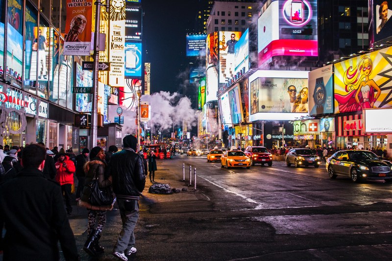 pedestrians walk through the brightly lit times square at night while cars drive past, times square never shined so bright 4k
