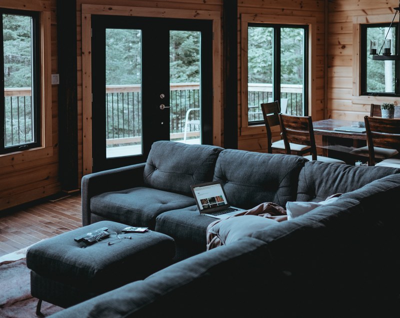 black leather couch in a well kept wooden cabin in the forest, working from home 4k