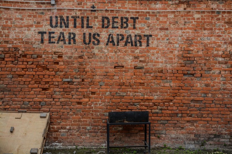 graffiti on an old brick wall reads until debt tear us apart, until debt tear us apart 4k