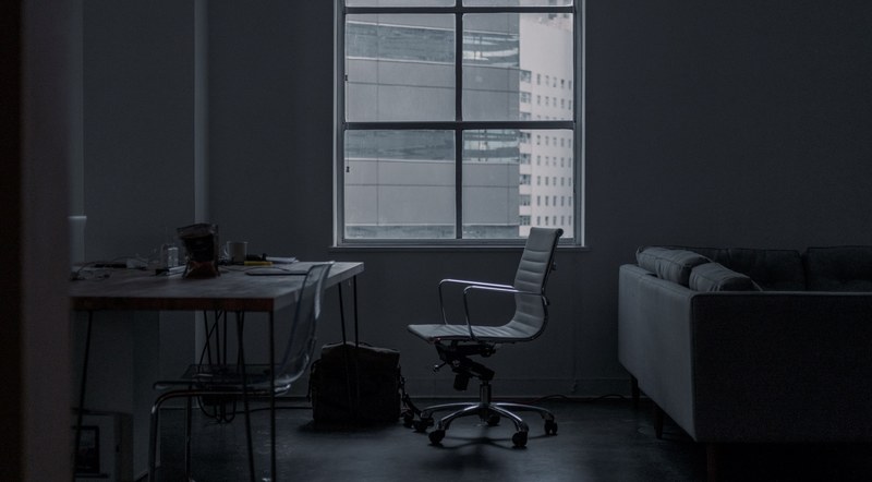 a bleak shot of a messy bedroom with an office chair a desk and a couch, moments in between work 4k
