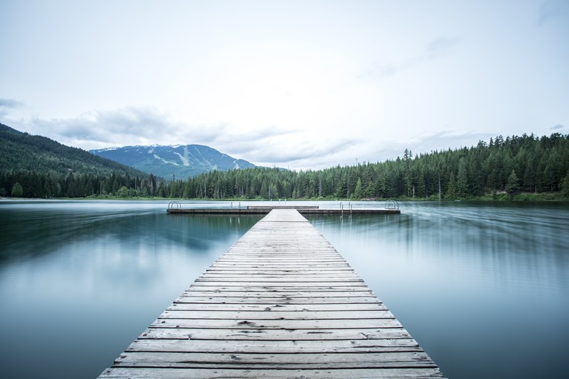 a long wooden pier on a smooth lake, long pier on a lake 4k
