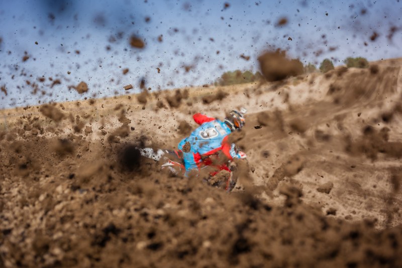 a motorcyclist riding a motorcycle and throwing up dirt and mud with the tires on a track, muddy motorcycle 4k