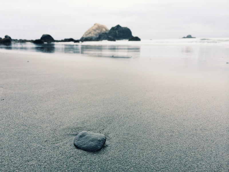 small rock on the fine wet sand beach coast, small rock on the beach 4k