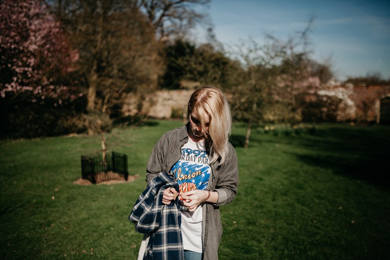woman carrying a flannel shirt and walking through a yard, walking in the yard 4k