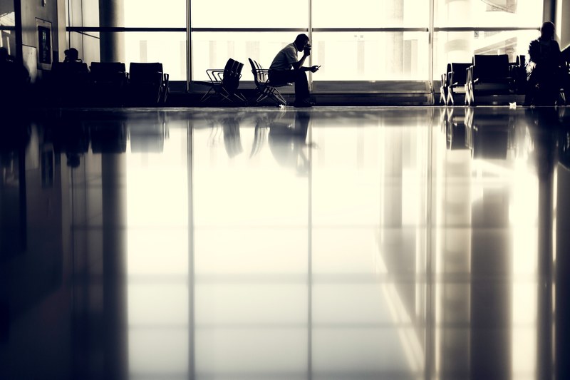 a man waiting in a chair at the airport, waiting for plane 4k