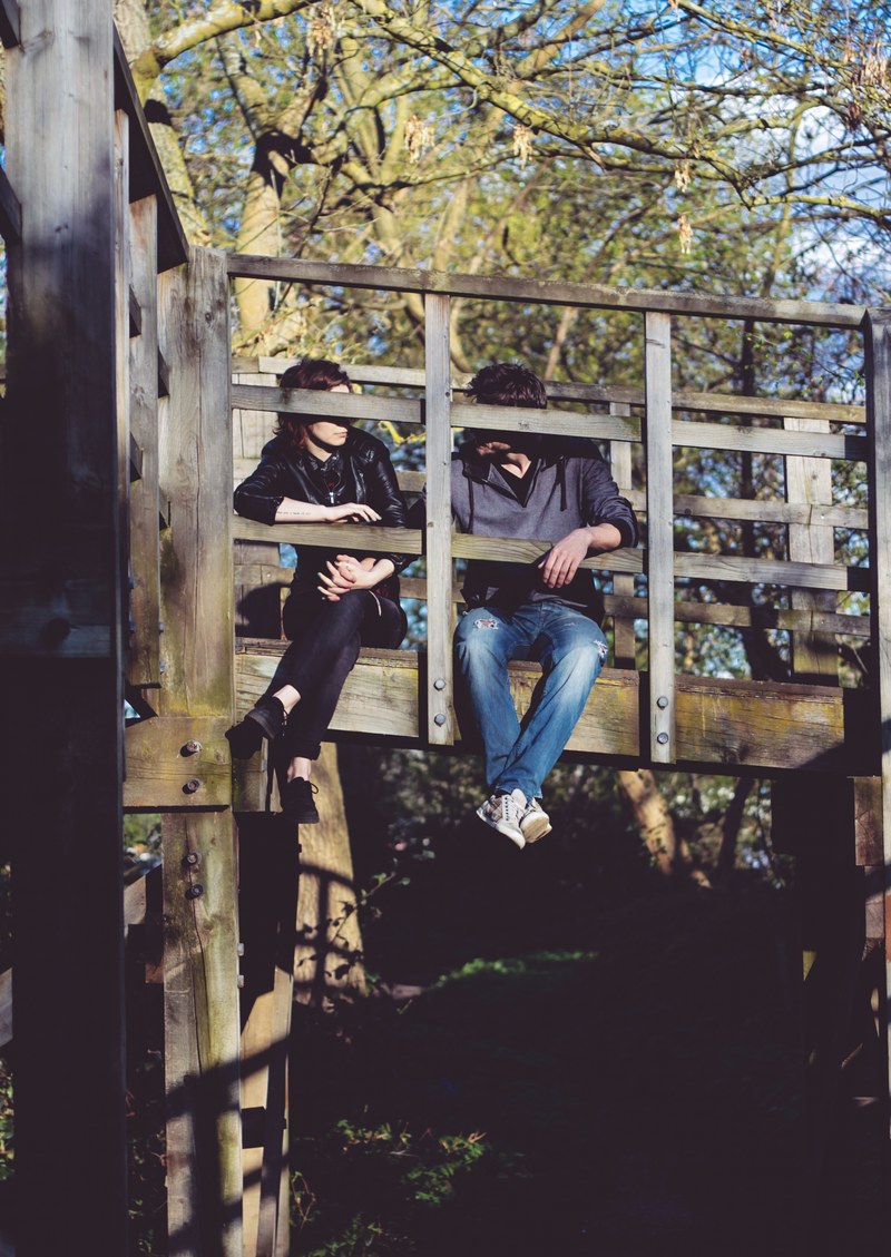 a couple sitting on a wooden dock in london, london couple dock 4k