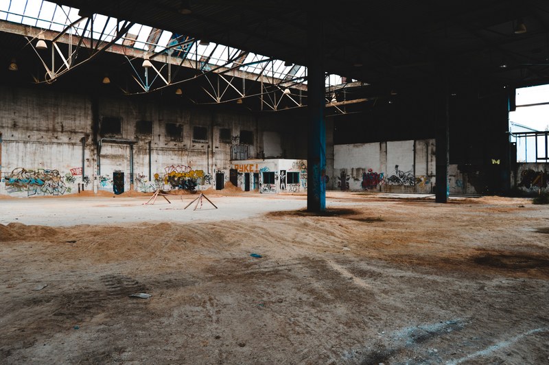 abandoned warehouse with dark columns dirt floors and graffitied walls, abandoned graffiti warehouse 4k