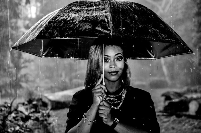 black and white shot of fashionable woman with necklaces under umbrella in pouring rain, woman and pouring rain 4k