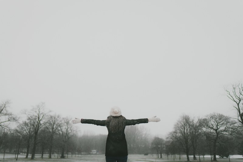 a woman embraces the winter in tree filled towneley park in burnley england, winter in towneley park 4k