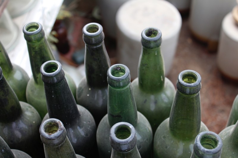 the top view of a collection of old green empty liquor bottles covered in dust, dusty wine bottles 4k