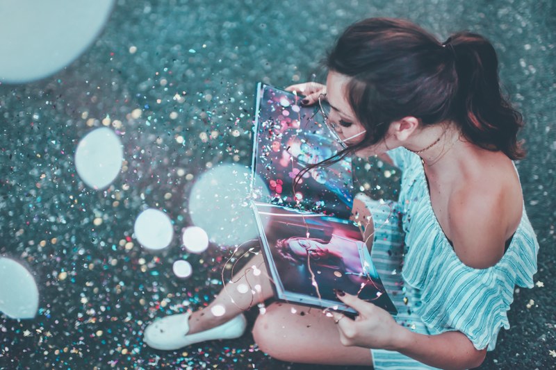 girl reads a magical photo book with glitter 4k