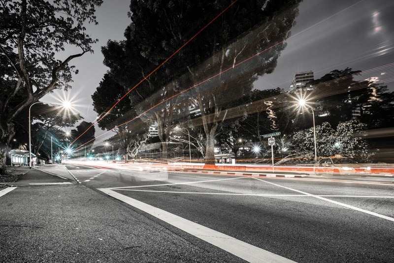 a desaturated long exposure shot of an empty road with light trails, light trails on an empty road 4k