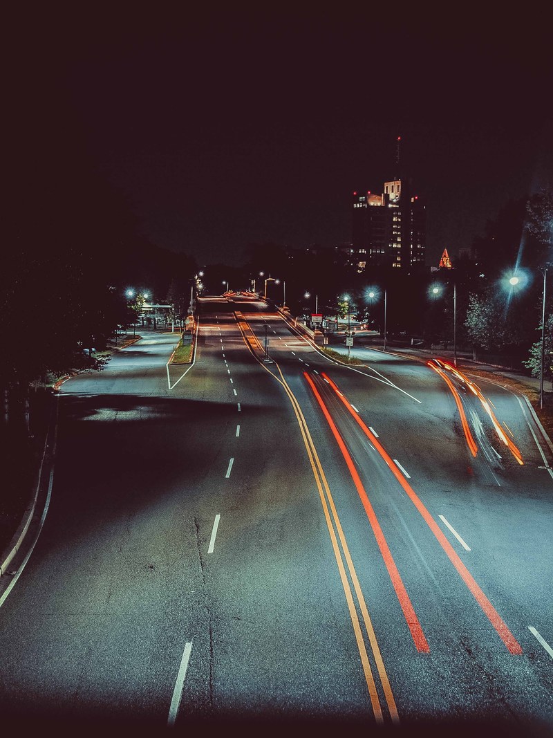 brake light trails from night traffic shown on an urban city street, night time traffic light trails 4k