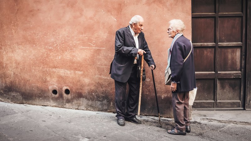 an old man and woman having a conversation with their canes next to a doorway, _old people conversing 4k