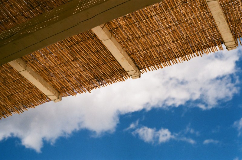 view at the thatched roof with woven rattan and a blue sky at argostoli, hut roof 4k