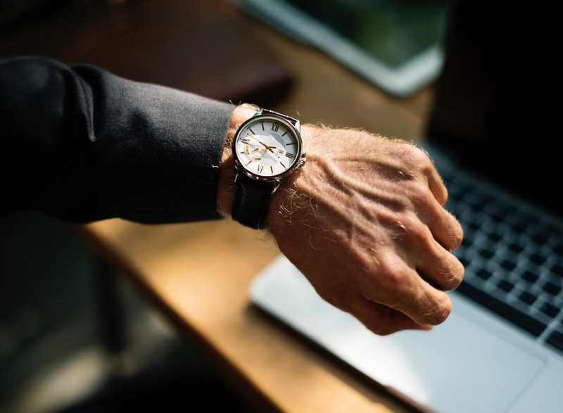 a man in a black suit checking the time on an elegant watch, elegant business watch 4k