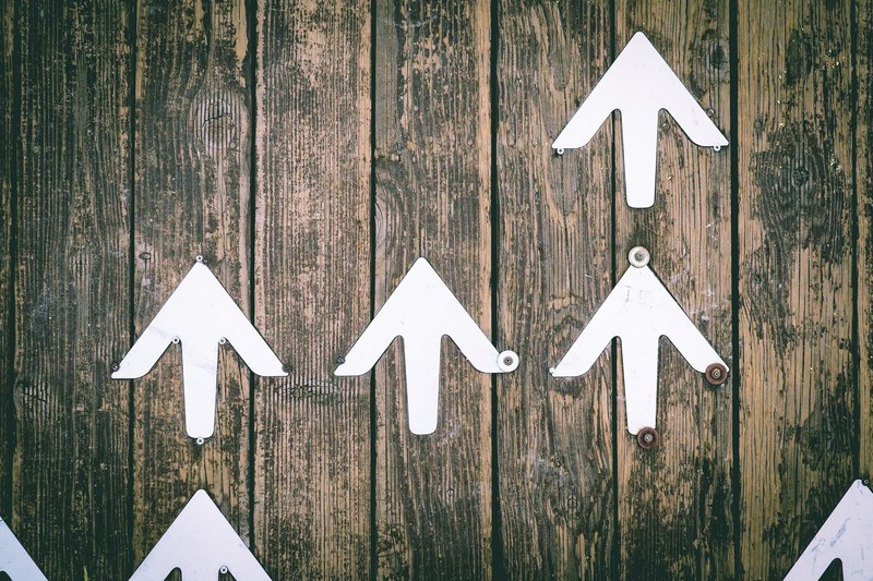 several white arrows pointing upwards on a wooden wall, upwards arrows 4k