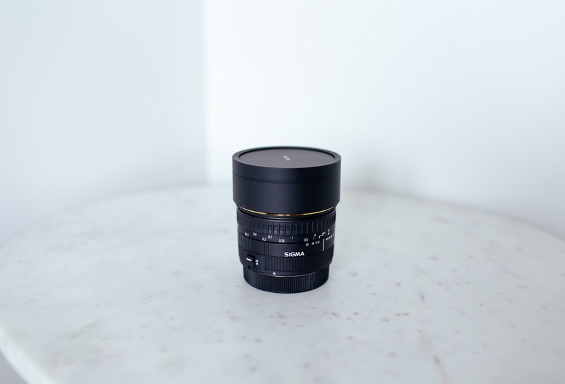 a sigma dslr camera lens on a white marble table, sigma lens 4k