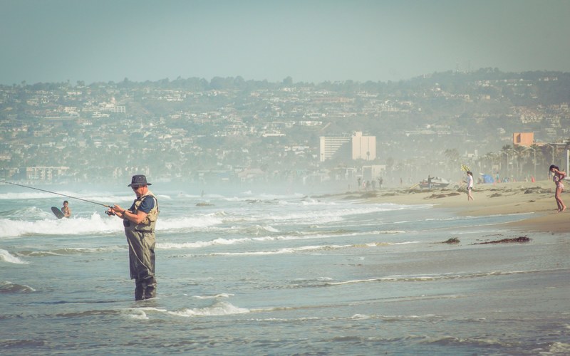 near shore view of fisherman fishing in a beach, fisherman fishing in beach 4k