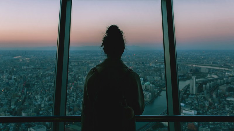 a womans silhouette looking out into the city during sunset at the tokyo skytree, tokyo skytree sunset 4k