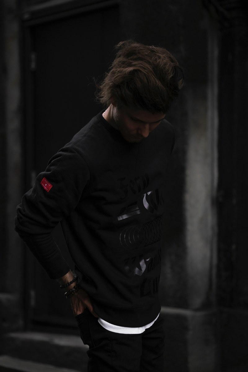 a person in silhouette poses in dark clothing against a dim background, the urban explorer sweatshirt 4k
