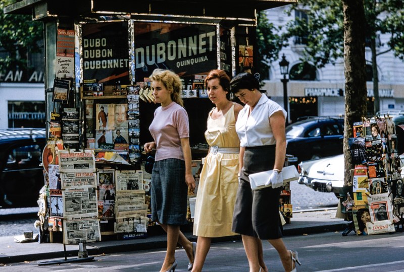 three women in retro clothes walk on the sidewalk by a news stand, three retro women 4k