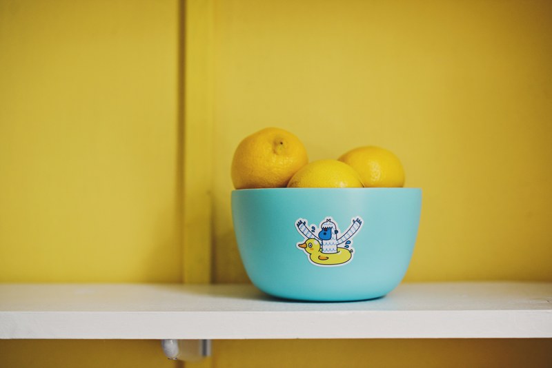 lemons in a blue bowl with a sticker on it against a yellow wall, when life gives you lemons 4k