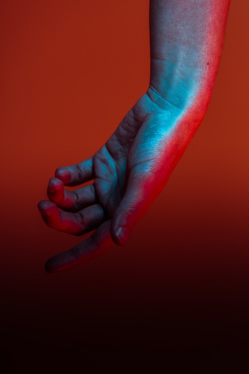 a hand reflecting a blue and red light on it, hand reflecting light 4k