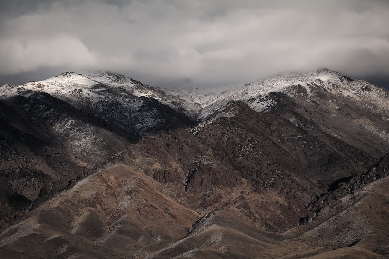 a snowy mountain with a shrub covered slope in nevada, snow capped peaks 4k